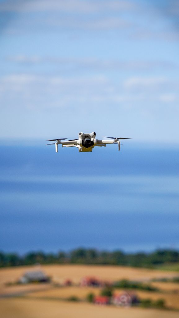 Drone survolant un littoral bordé de champs, prise de vue aérienne