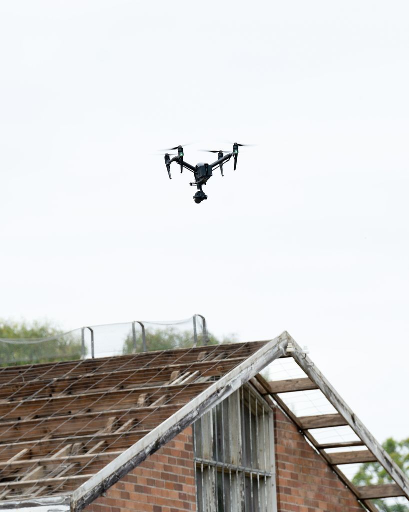 Drone en vol au-dessus d'une toiture ancienne, inspection de toiture par drone