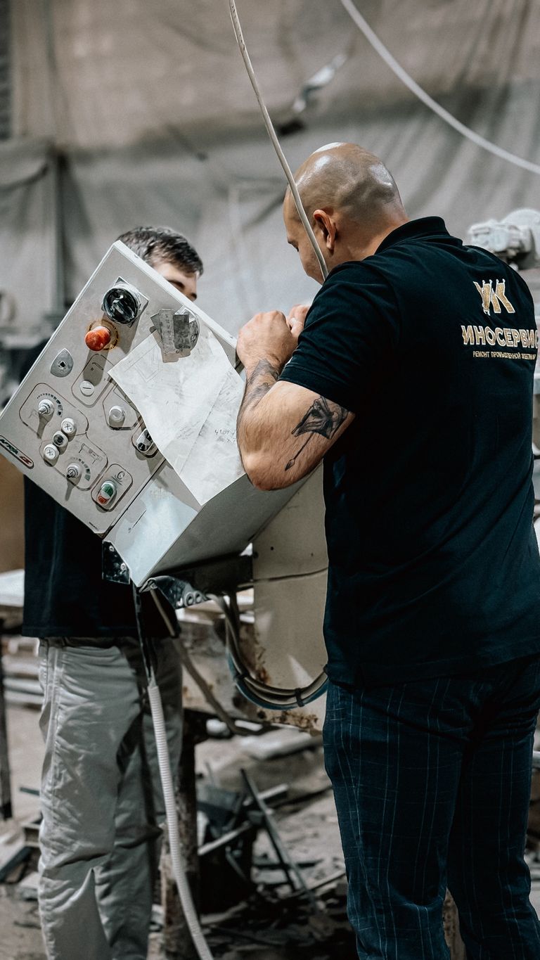 Techniciens de maintenance intervenant sur une armoire de commande en milieu industriel