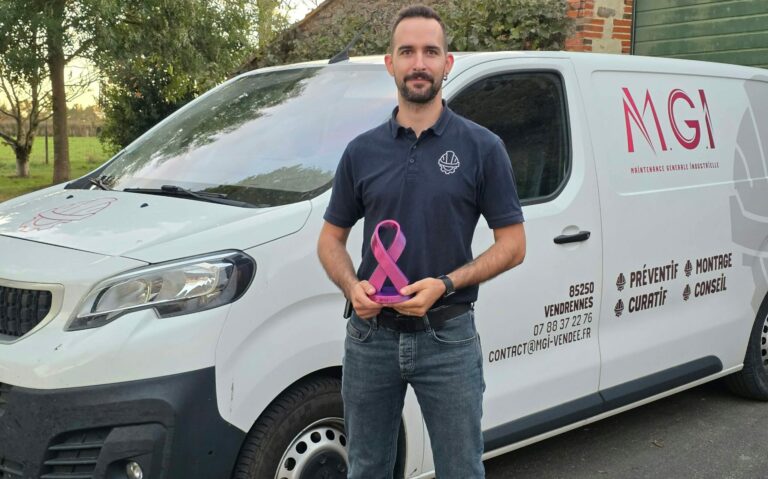 Dirigeant de MGI Maintenance Générale Industrielle devant son véhicule professionnel, tenant un ruban rose en soutien à Octobre Rose 2026.